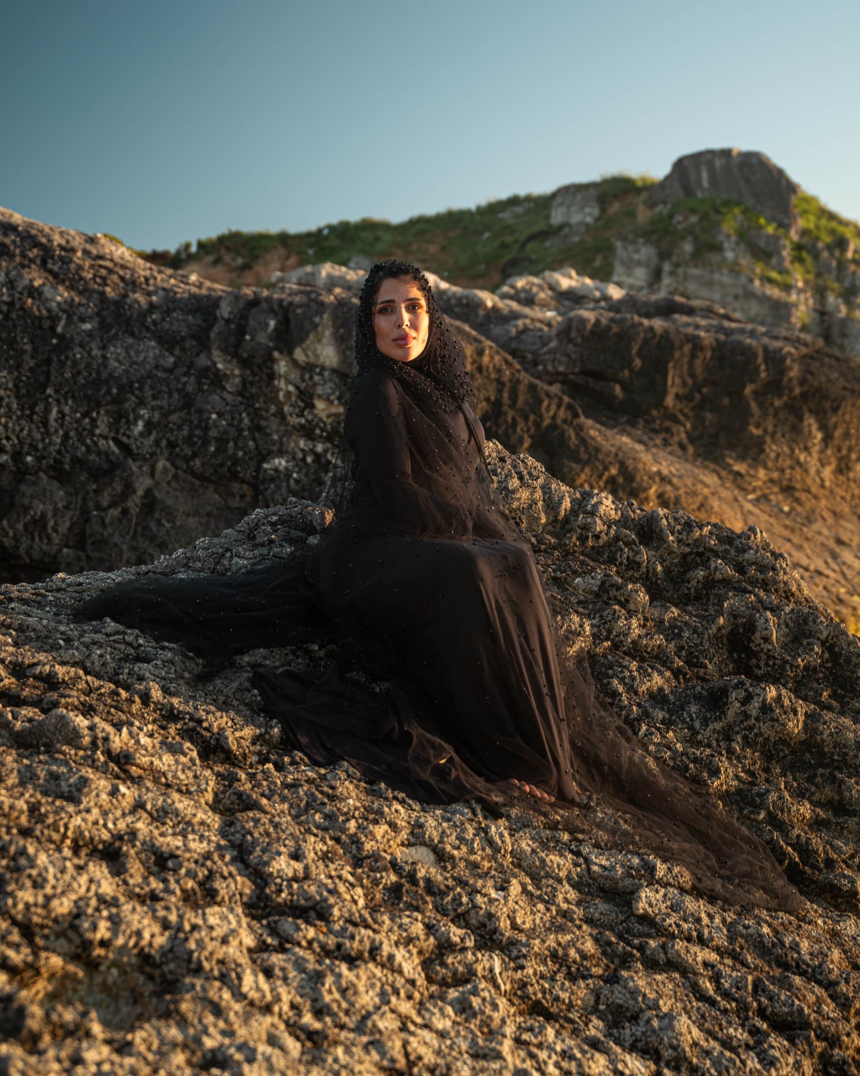 A figure on golden rocks at sunset
